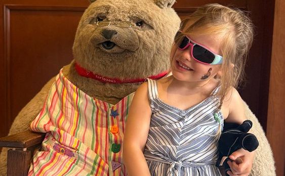 Our daughter smiling beside the big chocolate shop bear in Stratford