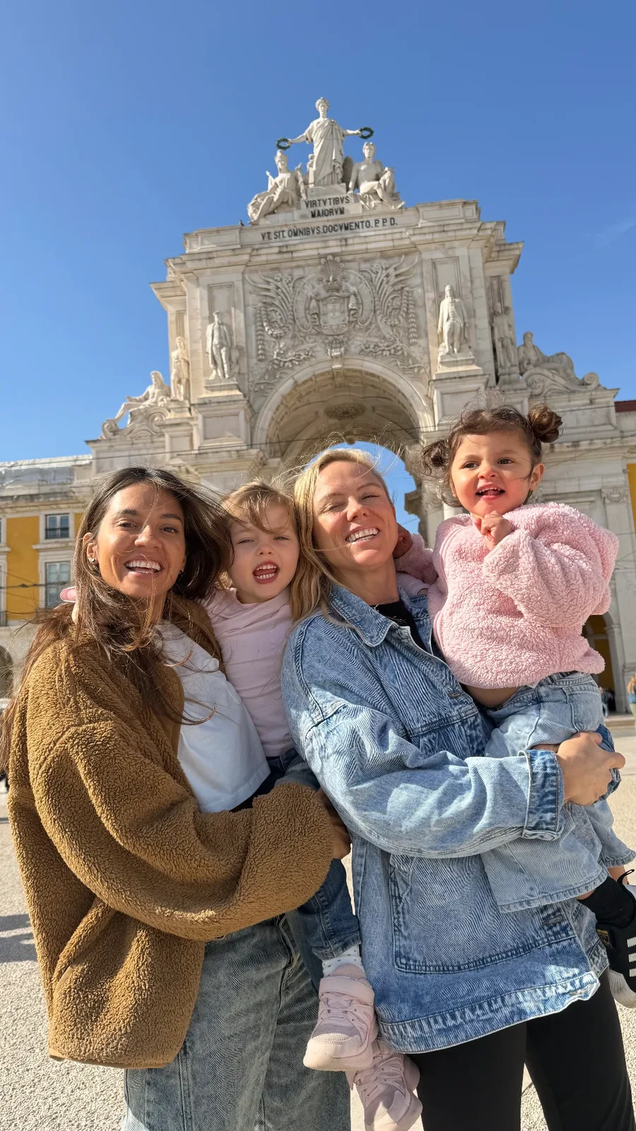 Our family beneath a landmark arch in Lisbon